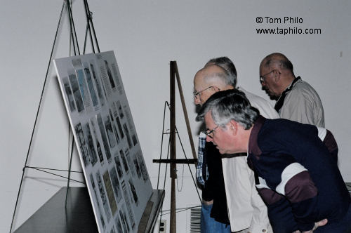 Members and Guests look at a photo display of Clint Gruber's time in the 8th Air Force - including 1 1/2 years in Stalag Luft III (Barth) photos of the camp.